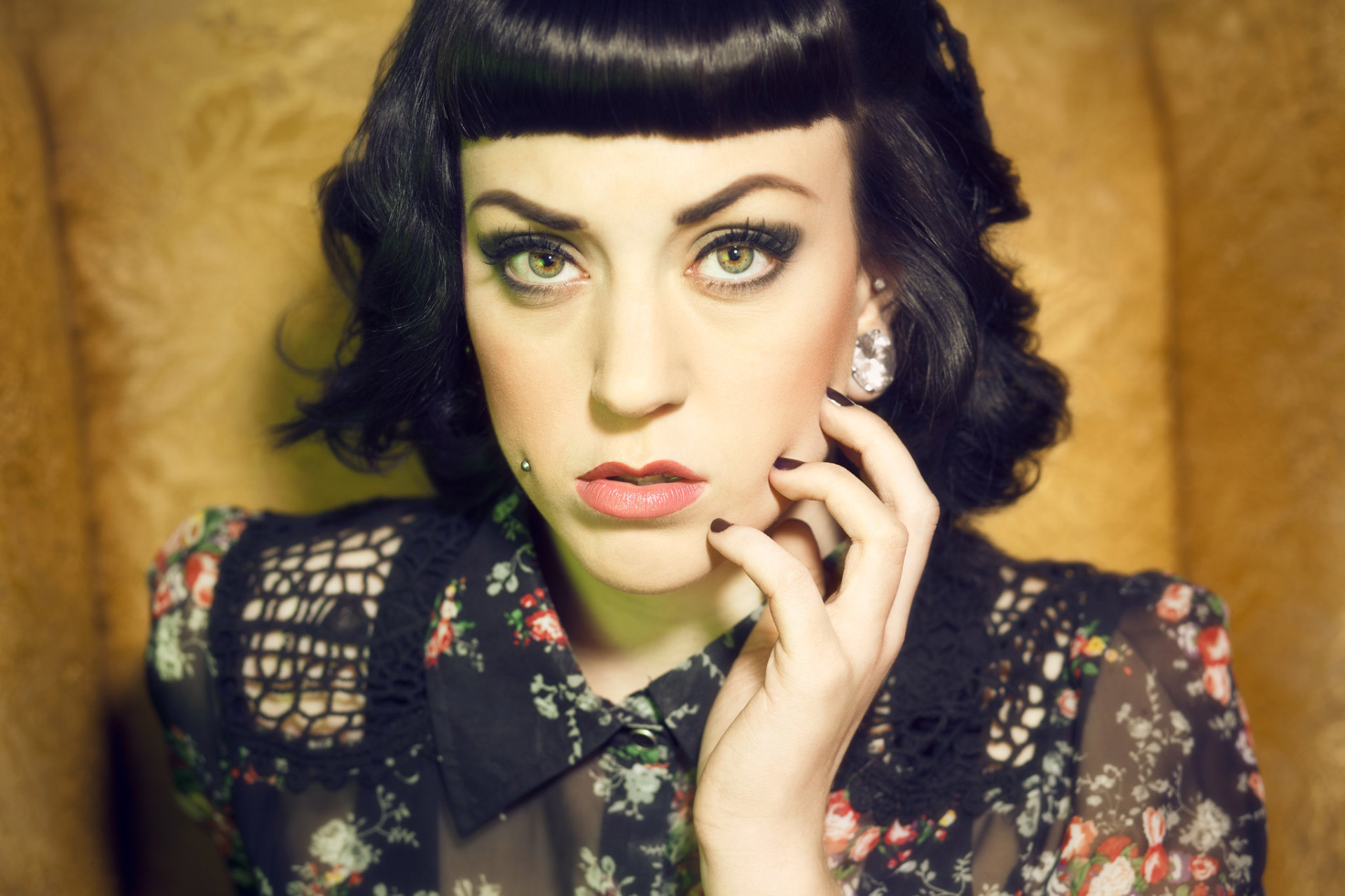 goth woman with hand on face